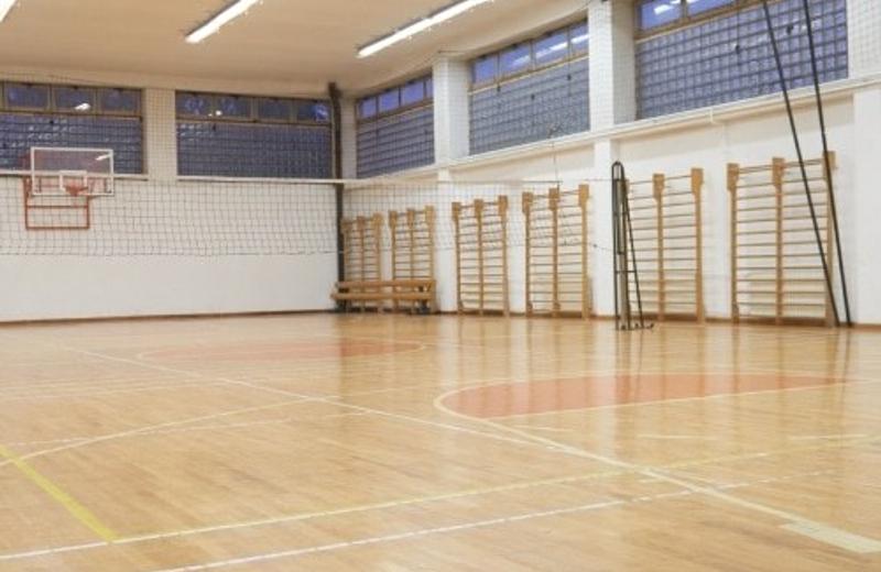 Commercial cleaning for colleges A school gymnasium with a polished wooden floor and wall bars