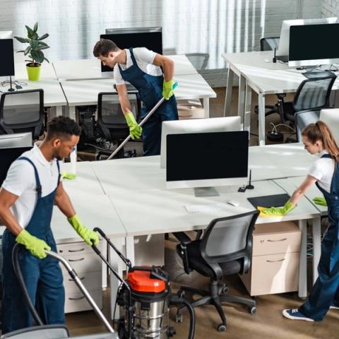 Auckland's first choice for commercial cleaning The 21st Century Cleaning team vacuuming, mopping and wiping down desks in an open-plan office